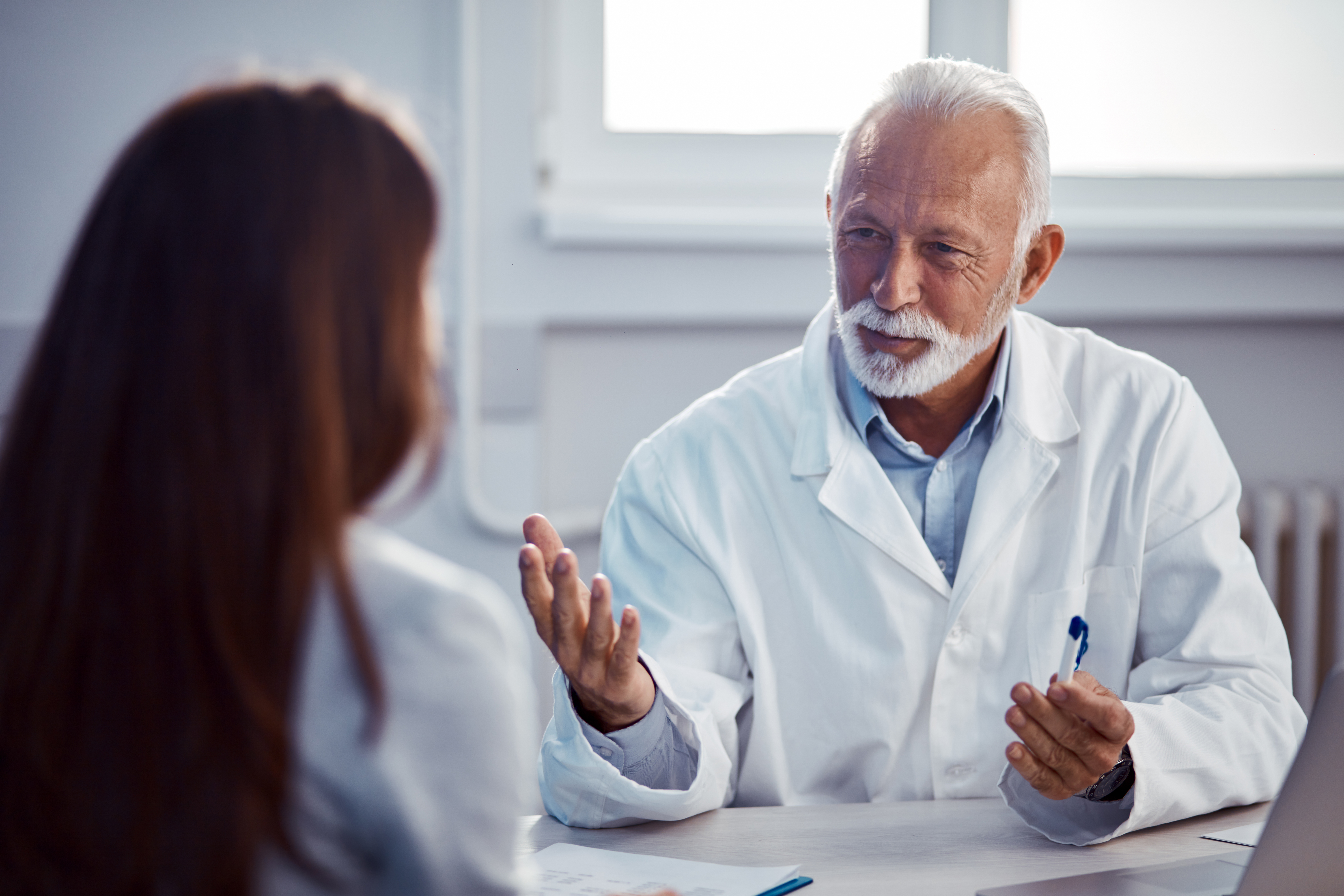 Senior physician speaking with a patient during an office visit