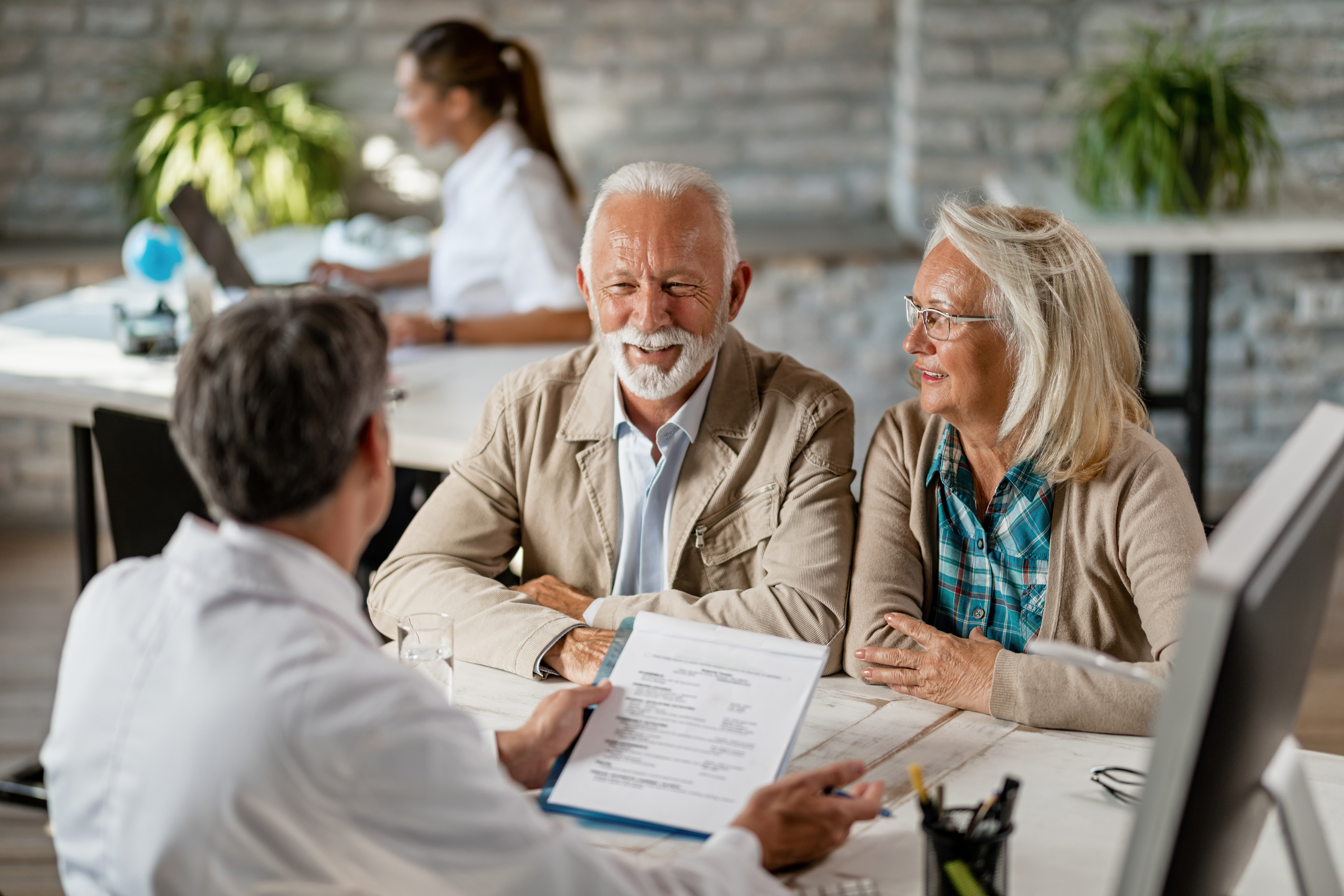 Older couple reviewing paperwork with a physician