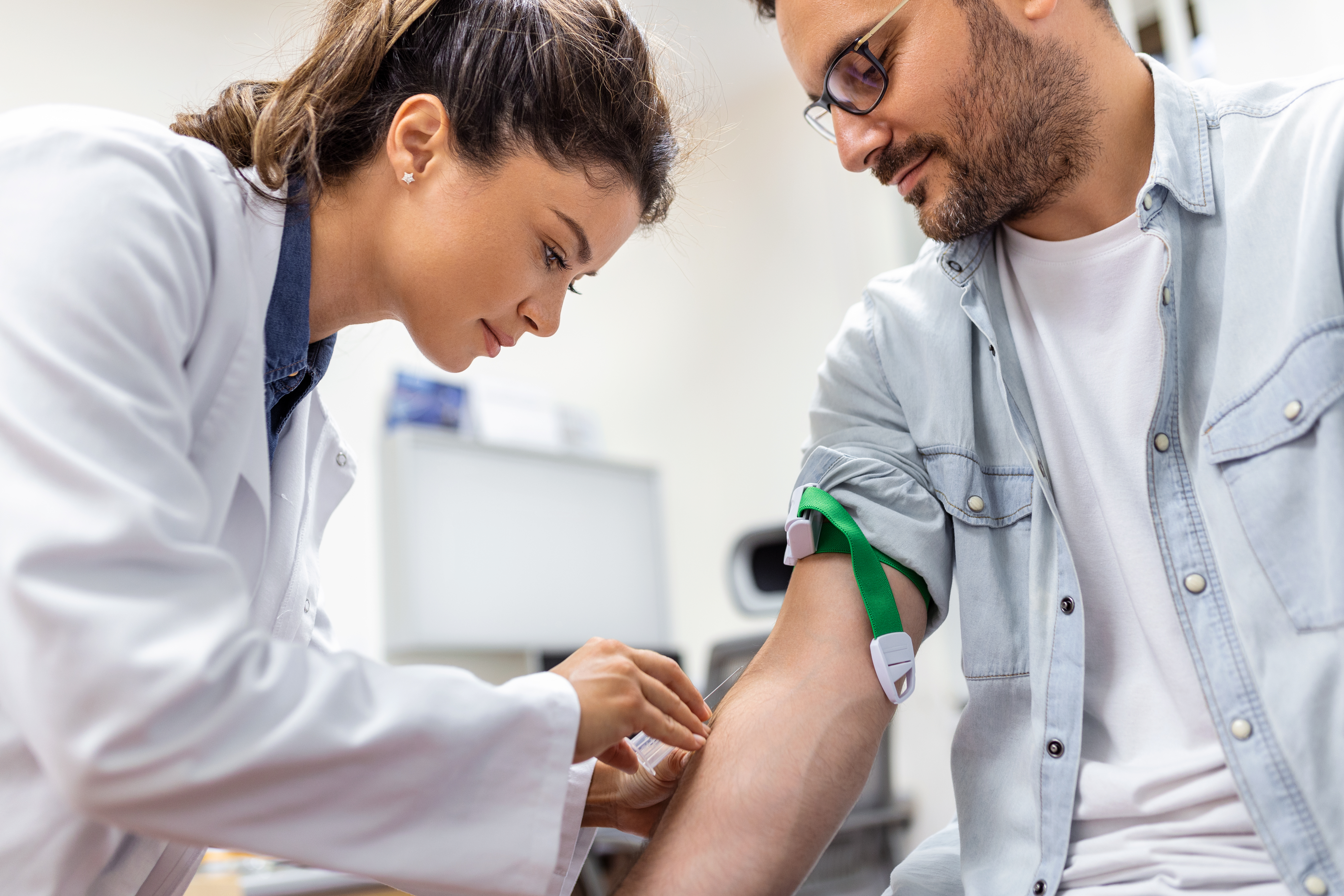 Clinician drawing blood from a patient's arm
