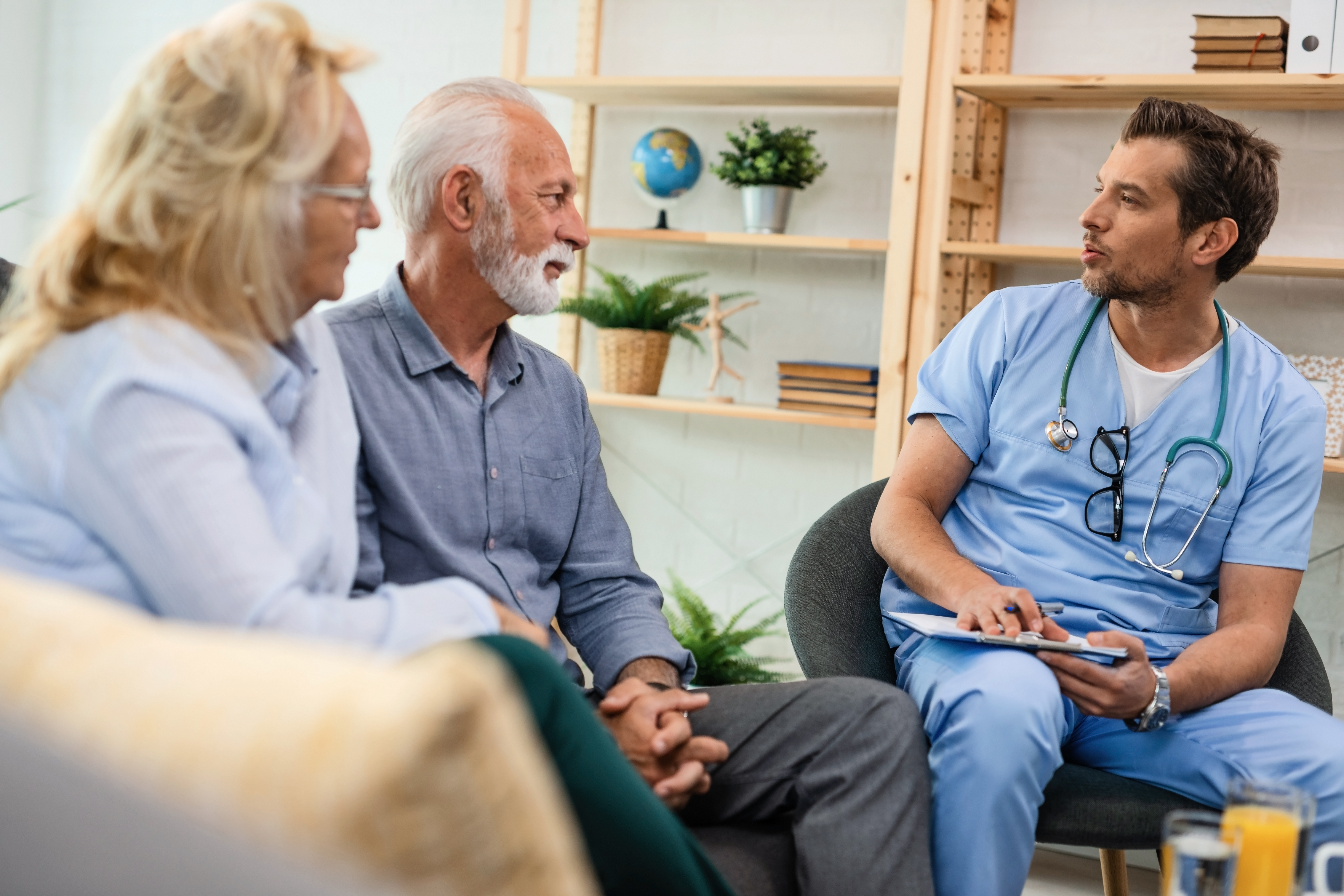 Clinician talking with an older couple during a home visit